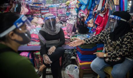 Pedagang beraktivitas di tokonya saat pemberlakuan ganjil genap di Pasar Perumnas Klender, Jakarta.