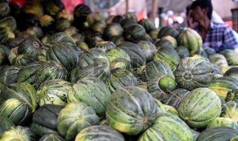 Pedagang buah blewah menanti pembeli di pasar Induk Kramat Jati, Jakarta, Rabu (24/6).