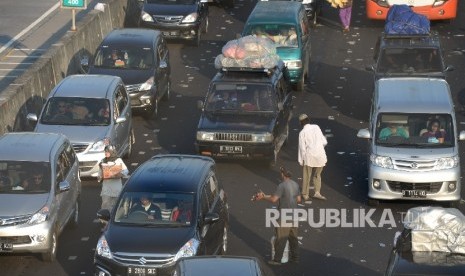 Pedagang dadakan menawarkan dagangan kepada pemudik terjebak macet parah di Tol Pejagan, Jawa Tengah, Senin (4/7).  (Republika/Wihdan Hidayat)