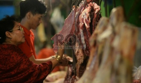 Pedagang daging sapi melayani pembeli.