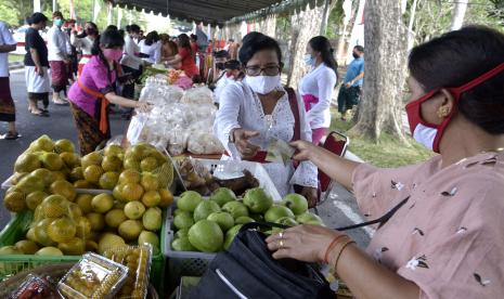 Pedagang dan pembeli melakukan transaksi saat kegiatan Pasar Gotong Royong Krama Bali di kawasan Renon, Denpasar, Bali, Jumat (14/8/2020). Kegiatan yang diselenggarakan setiap hari Jumat oleh sejumlah instansi pemerintahan, instansi vertikal, BUMN/BUMD dan pihak swasta di berbagai wilayah di Bali tersebut dilakukan sebagai upaya untuk memulihkan sektor ekonomi dengan mengatasi kendala pemasaran yang dihadapi petani, nelayan, perajin dan pelaku UMKM di tengah pandemi COVID-19.