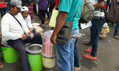 Pedagang es krim yang memberikan dagangannya secara gratis kepada peserta aksi 313, di sekitar Masjid Istiqlal, Jakarta, Jumat 31/3).