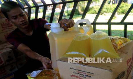 Pedagang keliling menata minyak goreng kemasan dan minyak goreng curah ke dalam mobil bak terbuka di kawasan Desa Tungkop, Darussalam, Aceh Besar, Aceh, Kamis (6/1/2022). Pemerintah bekerja sama dengan Badan Pengelola Dana Perkebunan Kelapa Sawit (BPDPKS) akan menyediakan 1,2 miliar liter minyak goreng untuk masyarakat dengan harga jual Rp14 ribu per liter di tingkat konsumen di seluruh Indonesia selama enam bulan ke depan. 