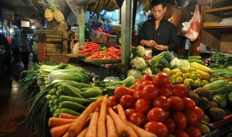 Pedagang komoditas bahan makanan melayani pembeli di pasar tradisional. ilustrasi