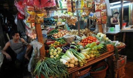 Pedagang komoditas bahan makanan melayani pembeli di Pasar Benhil, Jakarta, Senin (2/6).