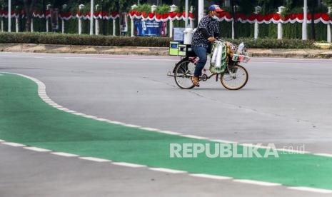 Pedagang kopi keliling melintas di jalur penyekatan Pemberlakuan Pembatasan Kegiatan Masyarakat (PPKM), Jakarta, Ahad (1/8/2021). Gubernur DKI Jakarta Anies Baswedan mengklaim kondisi penyebaran virus corona di Ibu Kota mulai melandai. Hal ini tak lepas dari kebijakan Pemberlakuan Pembatasan Kegiatan Masyarakat (PPKM) yang akan berakhir pada Senin (2/8/2021).