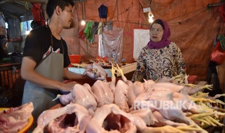 Pedagang melayani pembeli ayam potong di Pasar Minggu, Jakarta, Senin (15/4). 