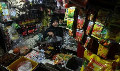 Pedagang melayani pembeli bahan makanan di Pasar Palmerah, Jakarta, Rabu (1/10).  ( Republika/Prayogi)