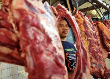 Pedagang melayani pembeli daging sapi di Pasar Tebet, Jakarta, Selasa (20/12). (Republika/Wihdan Hidayat)