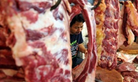 Pedagang melayani pembeli daging sapi di Pasar Tebet, Jakarta, Selasa (20/12). (Republika/Wihdan Hidayat)