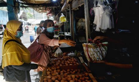 Pedagang melayani pembeli di kios telur Haji Darmuji, Pasar Minggu, Jakarta, Selasa (23/11/2022).