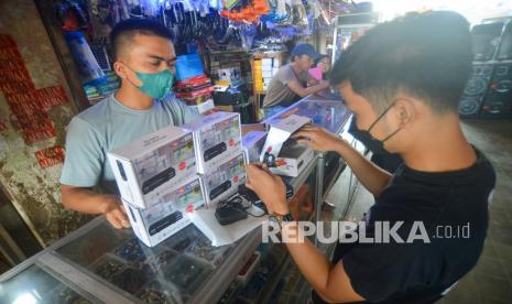 Pedagang melayani pembeli set top box (STB) TV Digital di pusat elektronik Blok AA Pasar Raya Padang, Sumatera Barat, Rabu (30/3/2022). Penjualan set top box yang dijual mulai Rp200 ribu tersebut masih sepi pembeli karena konsumen menganggap migrasi TV analog ke digital masih lama yakni pada 30 April 2022. 