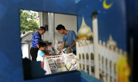   Pedagang melayani pembeli yang memilih kartu Lebaran di Kompleks Kantor Pos Perwakilan Jakarta Pusat, Jakarta, Senin (13/8). (Aditya Pradana Putra/Republika)