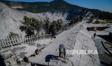 Pedagang membersihkan atap kiosnya dari debu vulkanik pascaerupsi Gunung Tangkuban Perahu  (ilustrasi)