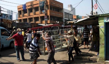  Pedagang membongkar lapaknya sendiri saat penertiban PKL di kawasan Pasar Tanah Abang, Jakarta Pusat, Ahad (11/8). (Republika/ Yasin Habibi)