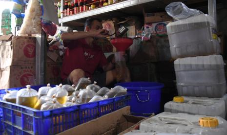 Pedagang membungkus minyak goreng curah untuk dijual di salah satu toko di kawasan Pasar Kebayoran Lama, Jakarta, Sabtu (21/5/2022). Komisi Pengawas Persaingan Usaha (KPPU) mengungkapkan terdapat kejanggalan pergerakan harga minyak goreng saat dan setelah kebijakan larangan ekspor sementara minyak sawit mentah atau CPO.