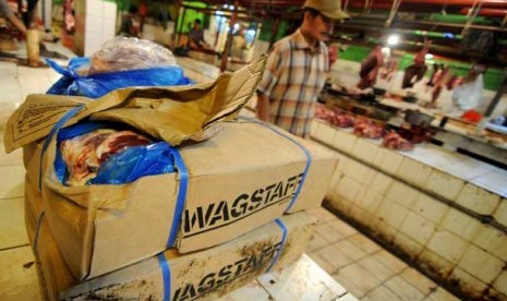 Pedagang memilah kotakan kardus berisi daging sapi impor Bulog di Pasar Jatinegara, Jakarta, Rabu (17/7).