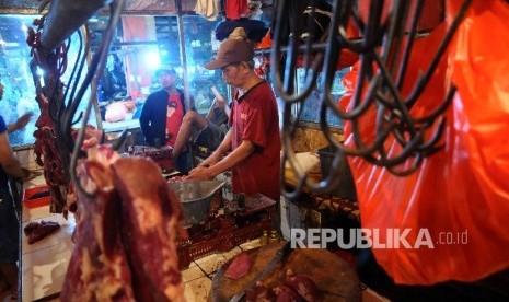 Pedagang memotong daging sapi di Pasar Grogol, Jakarta Barat, Selasa (27/12).