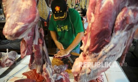  Pedagang memotong daging sapi di pasar tradisional.