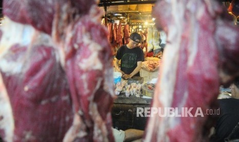 Pedagang memotong daging sapi yang di jual di pasar (ilustrasi)