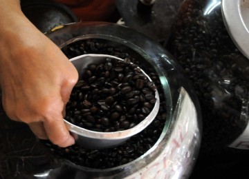 Pedagang mengambil kopi untuk ditimbang di Pasar Senen, Jakarta, Selasa (14/2). (Republika/Wihdan Hidayat)