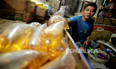 Pedagang mengemas minyak curah di lapaknya di Pasar Minggu, Jakarta, Rabu (29/6/2022). Kementerian Perdagangan memang telah berencana untuk mencabut kebijakan DMO. Namun, pemerintah membutuhkan komitmen pelaku usaha untuk tetap memastikan keamanan pasokan minyak sawit khususnya untuk minyak goreng di pasar domestik.