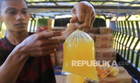 Pedagang mengemas minyak goreng curah di kawasan Desa Tungkop, Darussalam, Aceh Besar, Aceh, Kamis (6/1/2022). Pemerintah bekerja sama dengan Badan Pengelola Dana Perkebunan Kelapa Sawit (BPDPKS) akan menyediakan 1,2 miliar liter minyak goreng untuk masyarakat dengan harga jual Rp14 ribu per liter di tingkat konsumen di seluruh Indonesia selama enam bulan ke depan.