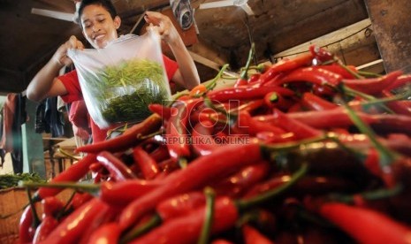   Pedagang mengemasi cabai-cabai yang dibeli pelanggannya di Pasar Senen, Jakarta, Rabu (13/3).   (Republika/Aditya Pradana Putra)