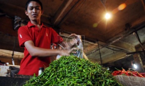   Pedagang mengemasi cabai-cabai yang dibeli pelanggannya di Pasar Senen, Jakarta, Rabu (13/3).   (Republika/Aditya Pradana Putra)