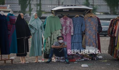 Pedagang mengenakan masker menunggu pembeli di Pasar Tasik, Jakarta.