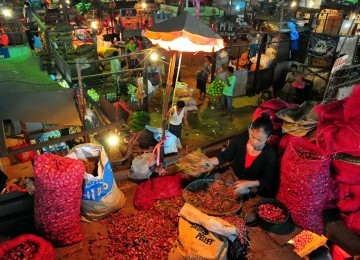 Pedagang mengupas bawang merah sebelum dijual di Pasar Induk Kramat Jati, Jakarta, Ahad (29/1). (Republika/Edwin Dwi Putranto)