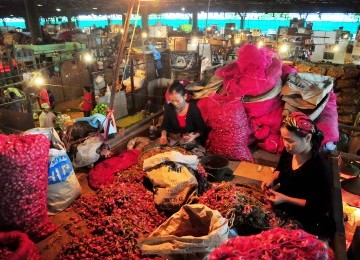 Pedagang mengupas bawang merah sebelum dijual di Pasar Induk Kramat Jati, Jakarta, Ahad (29/1). (Republika/Edwin Dwi Putranto)