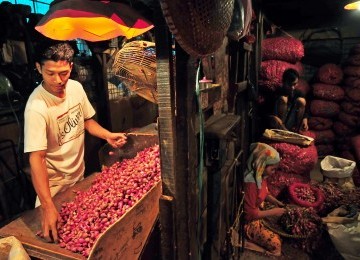 Pedagang mengupas bawang merah sebelum dijual di Pasar Induk Kramat Jati, Jakarta, Ahad (29/1). (Republika/Edwin Dwi Putranto)