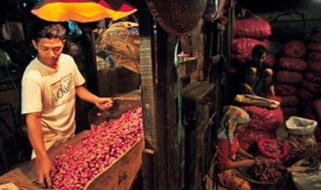 Pedagang mengupas bawang merah sebelum dijual di Pasar Induk Kramat Jati, Jakarta, Ahad (29/1). (Republika/Edwin Dwi Putranto)