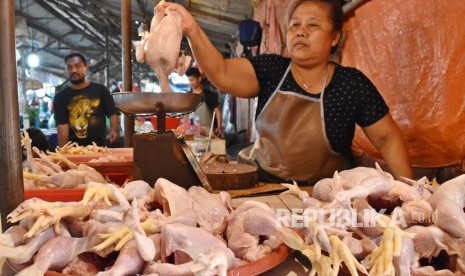 Pedagang menimbang ayam potong 