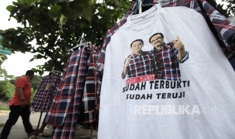 Pedagang menjajakkan atribut kampanye pasangan Ahok-Djarot di Rumah Lembang, Jakarta, Senin (19/12).