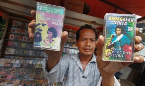 Pedagang menunjukkan kaset bekas yang dijual di Pasar Lama Tangerang, Banten, Kamis (7/11). (Antara/Rivan Awal Lingga)