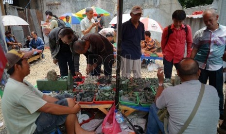 Pedagang menunjukkan koleksi batu Bacan di lapak PKL kawasan Pasar Rawa Bening, Jakarta Timur, Senin (13/10). Ragam batu cincin saat ini kembali banyak diburu oleh para kolektor perhiasan menimbulkan banyak bermunculannya pedagang batu musiman.