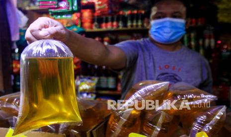 Pedagang menunjukkan minyak goreng curah di Pasar Agung, Depok, Jawa Barat, Rabu (8/12). 