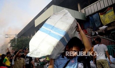  Pedagang menyelamatkan barang-barangnya dari lokasi Blok I dan Blok II Pasar Senen yang terbakar di Jakarta, Kamis (19/1).