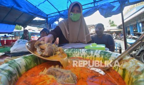 Pedagang menyiapkan katupek gulai tunjang untuk takjil di Pasar Kuraitaji, Pariaman, Sumatera Barat, Sabtu (17/4/2021). Katupek gulai tunjang adalah ketupat sayur khas Pariaman yang berisi tunjang atau bagian dari kaki sapi/kerbau yang tebal dan kenyal menjadi kuliner favorit untuk berbuka puasa yang dijual mulai Rp20 ribu hingga Rp60 ribu per porsi tergantung ukuran. 