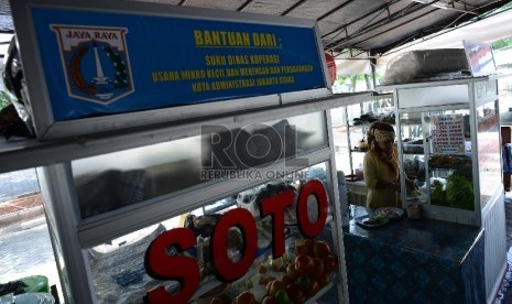 Pedagang menyiapkan makanan untuk dijual di tempat relokasi baru area barat parkir Mall Pluit Village, Jakarta Utara, Rabu (11/3).   (Republika/Raisan Al Farisi)