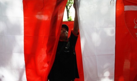 Pedagang merapikan dagangan bendera di kawasan Tebet, Jakarta, Kamis (7/8). Menjelang peringatan HUT-RI yang ke-69, banyak pedagang bendera merah putihdi jalanan, harga bendera berkisar Rp 15.000 sampai Rp 50.000 per bendera.