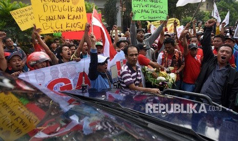 Pedagang Pasar Kemiri Muka membawa poster dan barang dagangan mereka saat menggelar aksi unjuk rasa menolak eksekusi lahan pasar di depan Pengadilan Negeri Kota Depok, Jawa Barat, Senin (16/4).