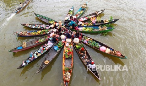 Pedagang Pasar Terapung melakukan atraksi Jukung (perahu) di Desa Lok Baintan, Kabupaten Banjar, Kalimantan Selatan.