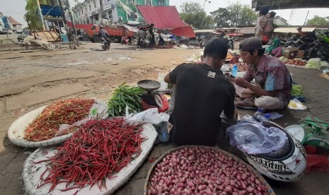 Pedagang sayuran sedang menunggui lapaknya yang sepi pengunjung di Pasar Baru Bekasi, Bekasi Timur, Kota Bekasi.