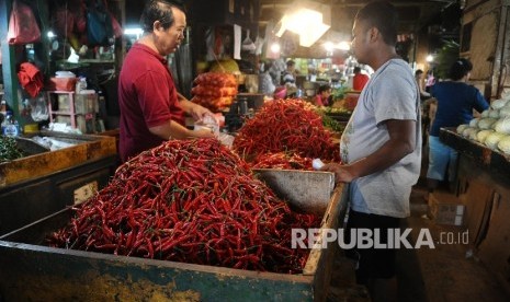  Pedagang sedang melayani pembeli cabai rawit merah di pasar tradisional, Jakarta, Senin (2\1). 