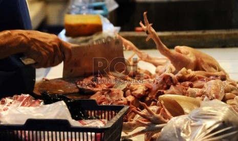 Pedagang sedang memotong ayam dilapak tempat berjualan di pasar tradisional, Jakarta, Selasa (4/8).