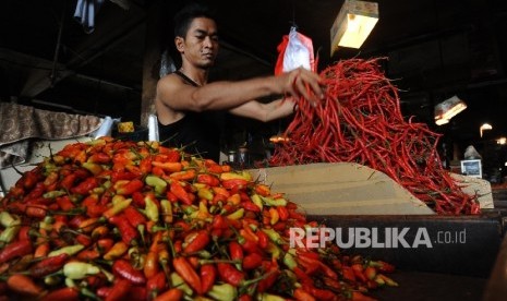 Pedagang sedang mengatur cabai pada kios di pasar tradisional.