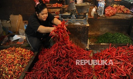 Pedagang sedang mengatur dagangan cabai merah keriting di salah satu pasar tradisional.